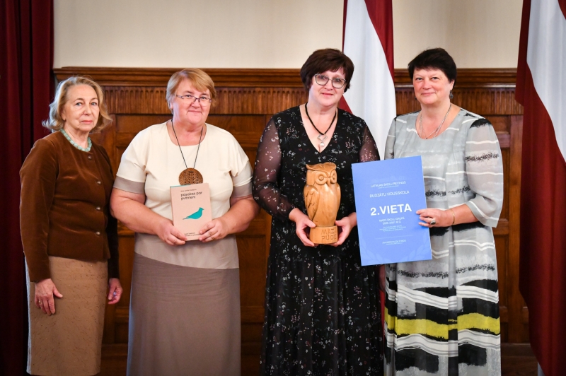 Četras sievietes ar diplomu un balvu